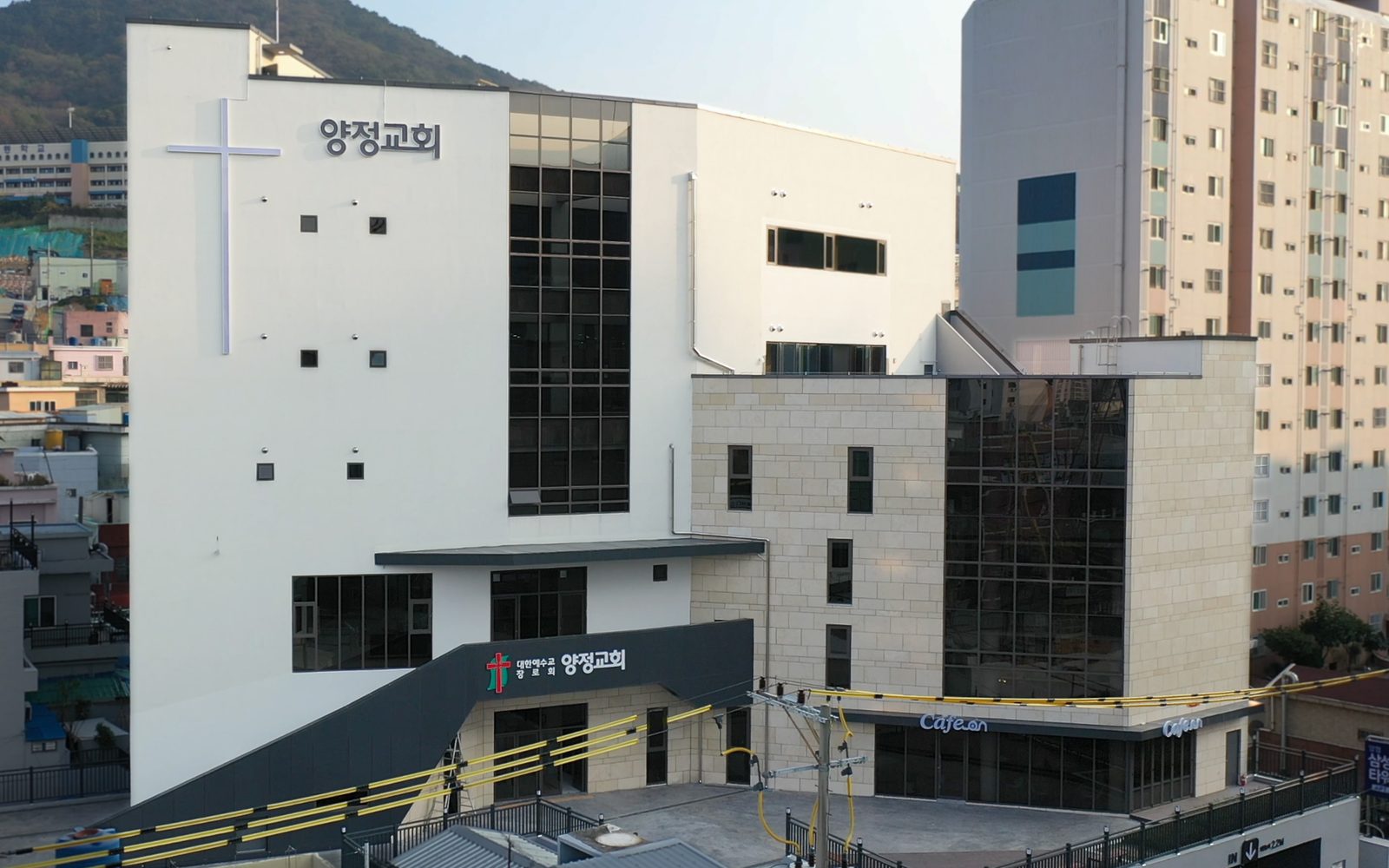 양정교회 건물 전경. 흰색 벽면에 십자가와 '양정교회' 글자가 있고, 오른쪽 1층에 카페가 붙어 있다.