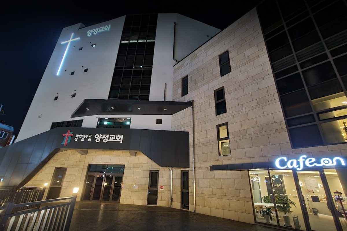 밤의 양정교회. 십자가와 '양정교회' 간판에 조명이 켜져 있고 오른쪽 1층에 Cafe On 이 있다.