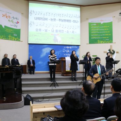 헌신예배에서 찬양팀이 기타와 함께 찬양을 인도하는 모습
